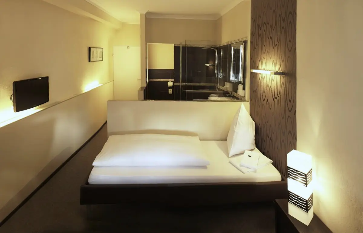 Einzelzimmer Standard mit warmem Licht im Hotel Goldener Falke in Augsburg-Oberhausen